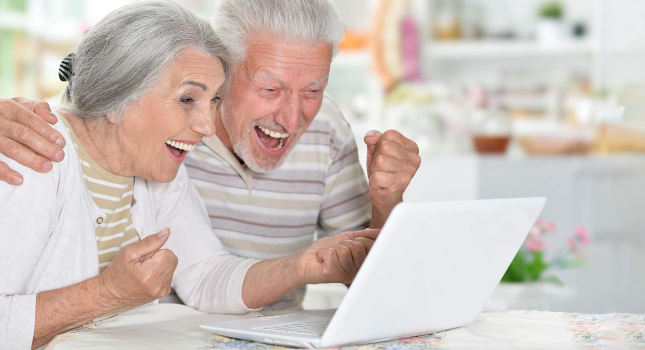 happy senior couple using laptop home